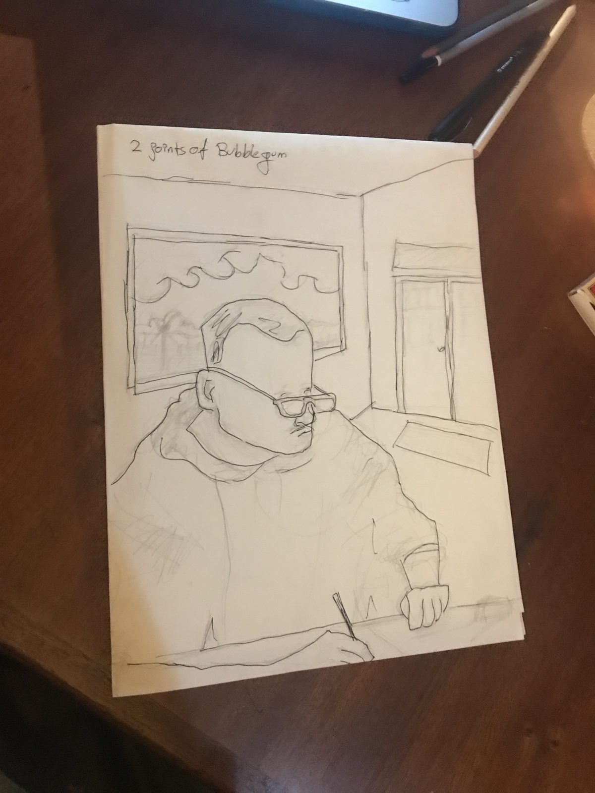 Pencil drawing of the man with glasses writing, a window behind him, noted: 2 joints of bubblegum