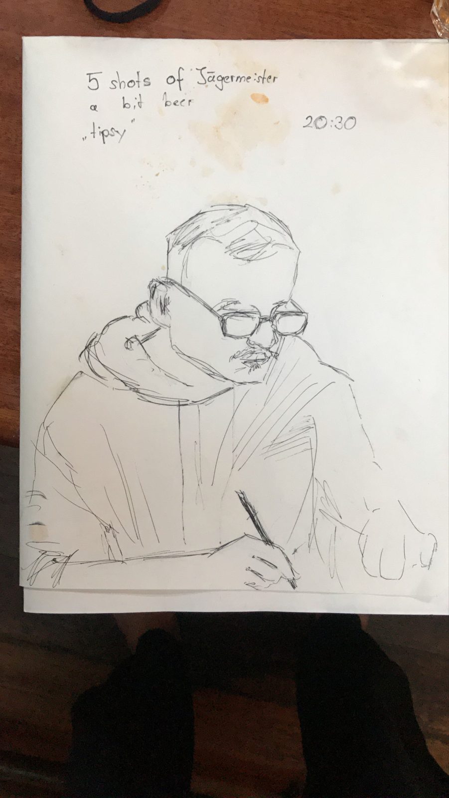 Ink drawing of the man with glasses writing, noted: 5 shots of Jägermeister, a bit beer, tipsy, 20:30