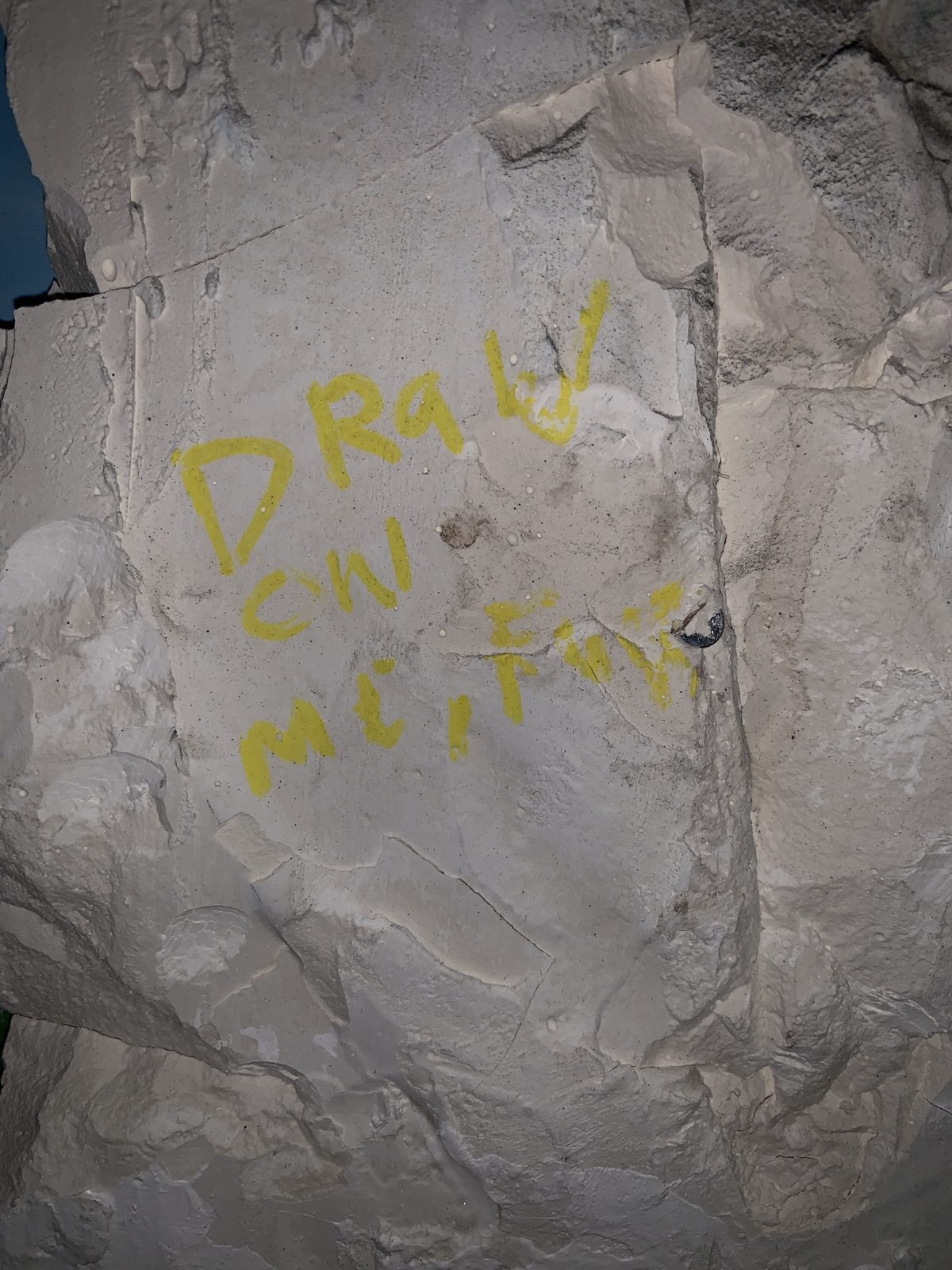 Detail: DRAW ON ME written in yellow