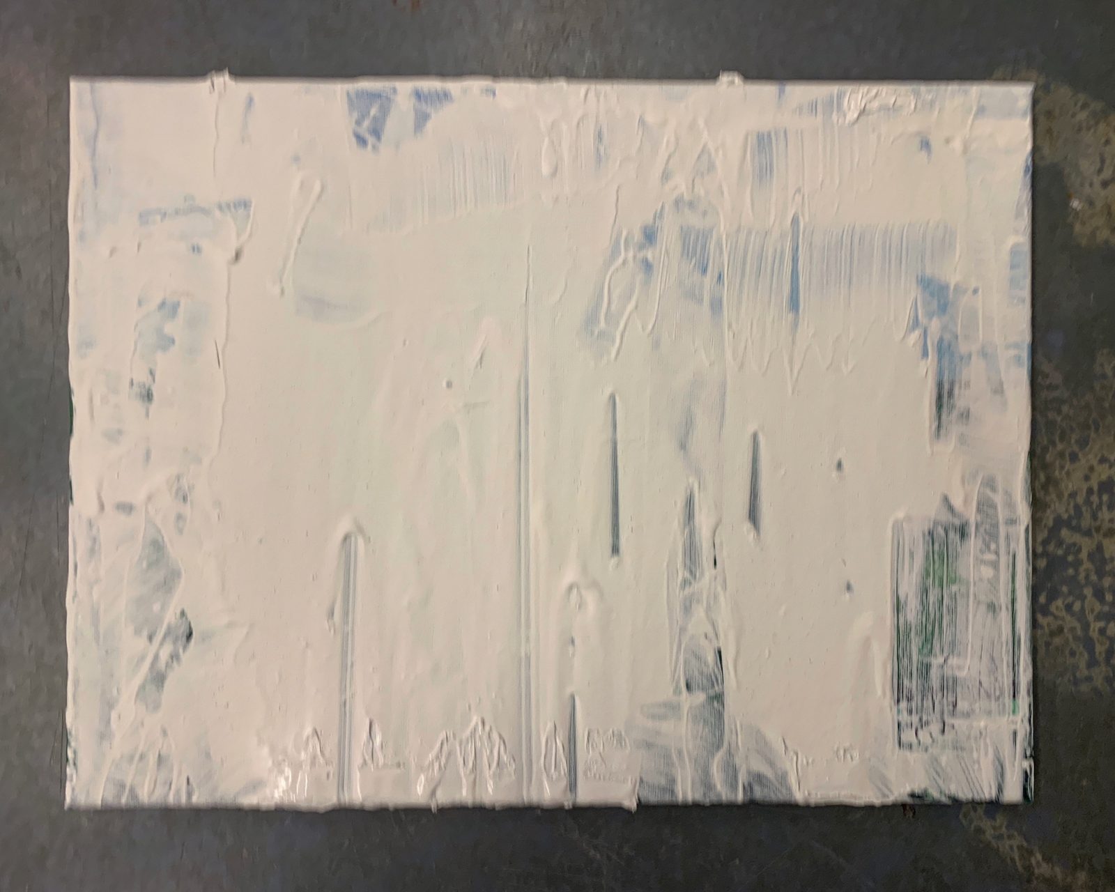 Another canvas covered in plaster, bits of sky and green showing through