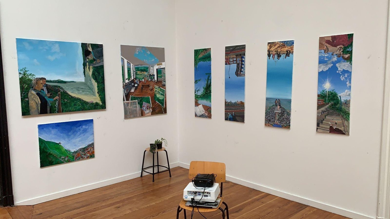 Paintings on display in a corner of a room