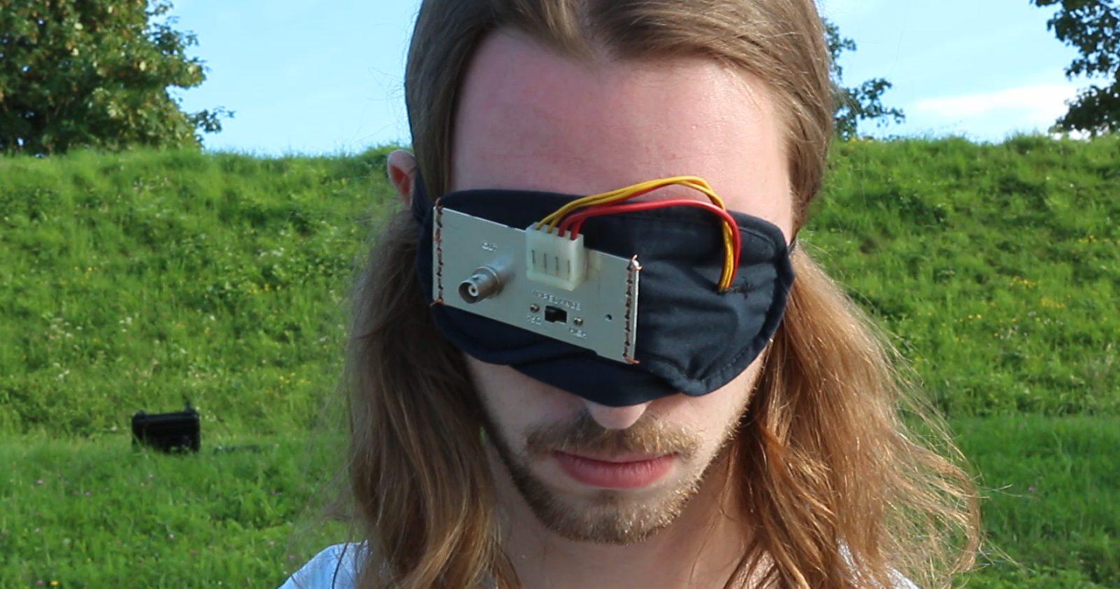 Pareidolia: the entranced person, blindfolded with a camera, on a riverbank